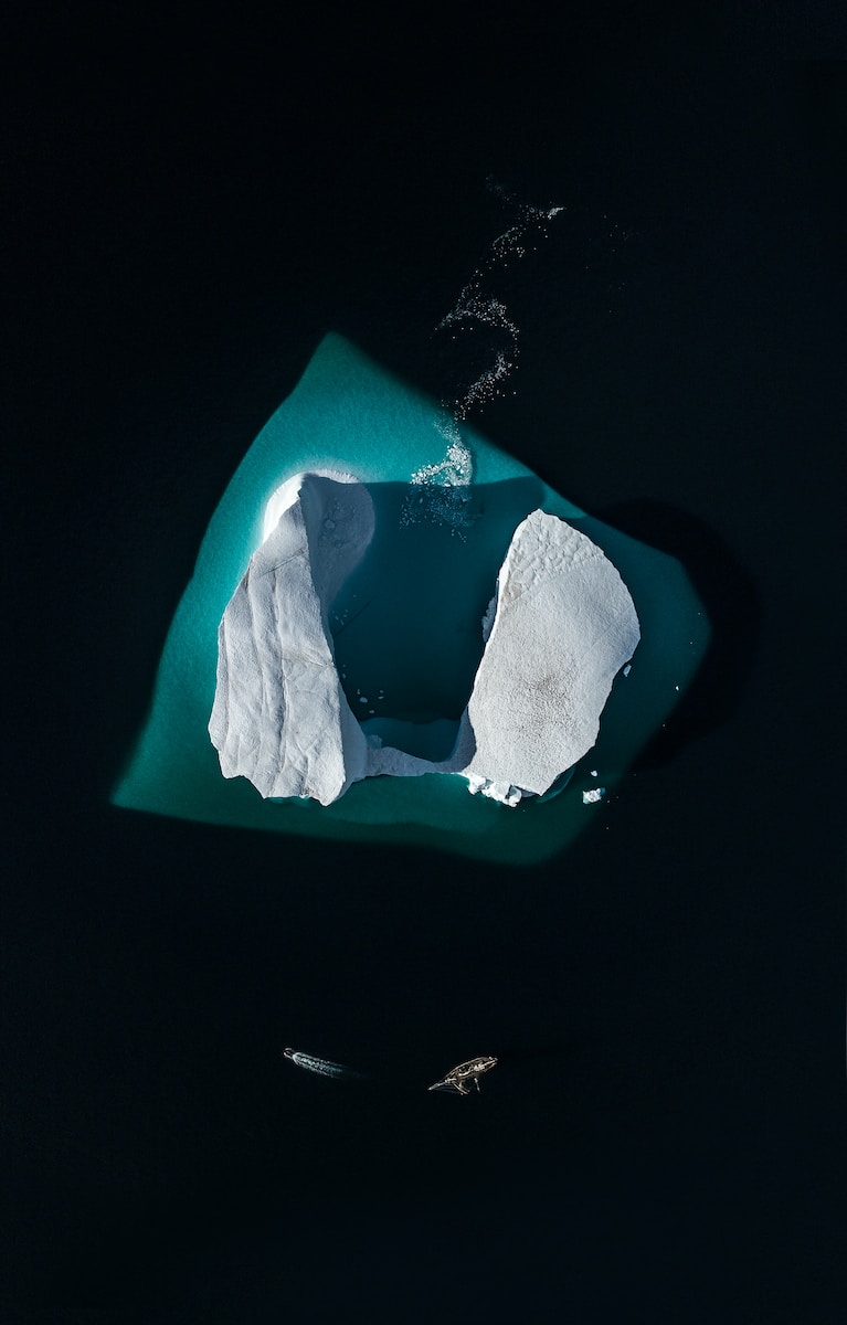 an aerial view of an iceberg in the water