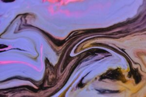 mix of multicolored paints swirling on uneven surface