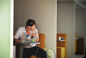 man in white shirt using macbook pro