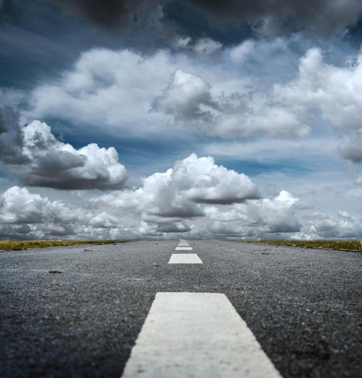 gray rolled asphalt road under cloudy sky